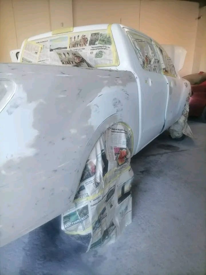 Classic car in a paint booth masked with newspapers